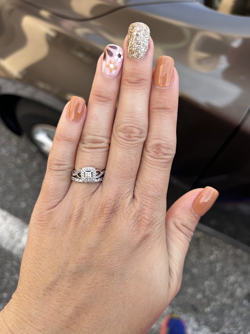 Nail technician painting acrylic nails in a salon chair