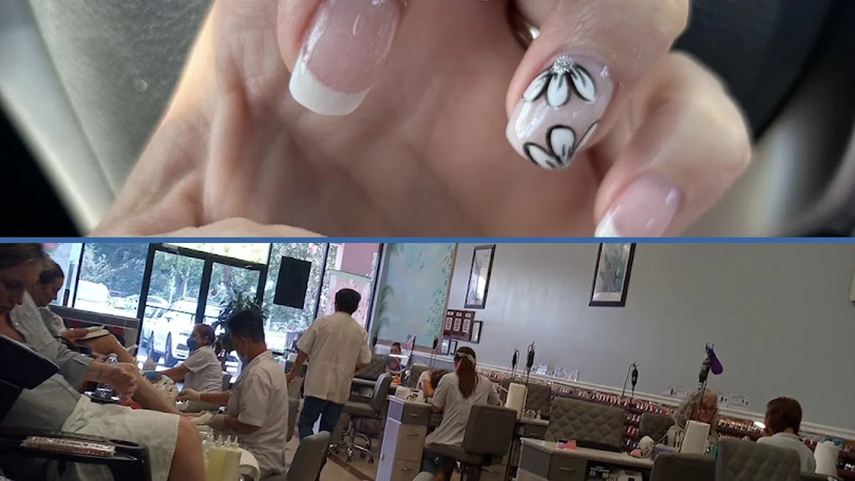 Nail technician painting acrylic nails in a salon chair